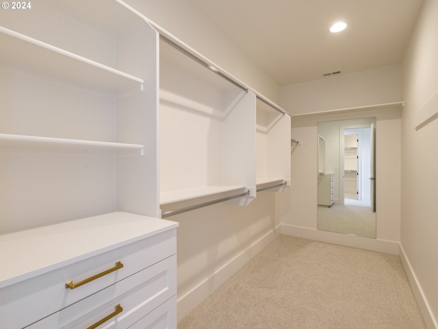 walk in closet featuring light colored carpet