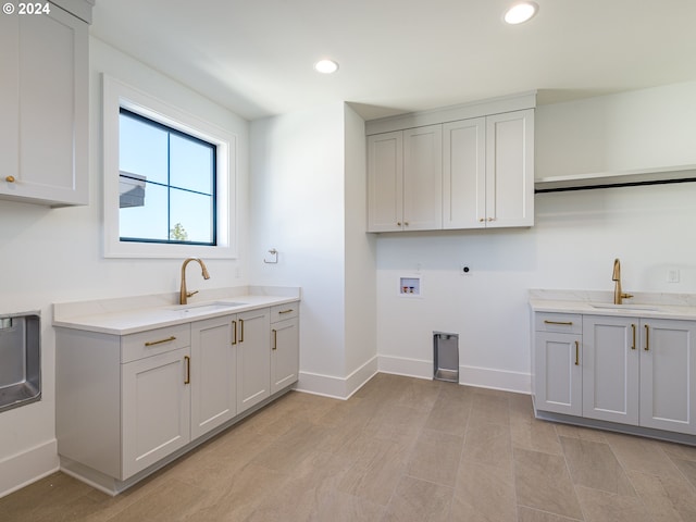 washroom with hookup for an electric dryer, cabinets, sink, and hookup for a washing machine