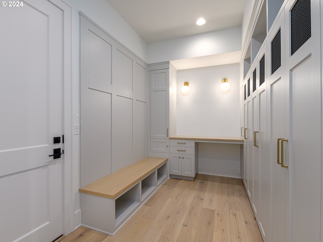 mudroom featuring built in desk and light wood-type flooring