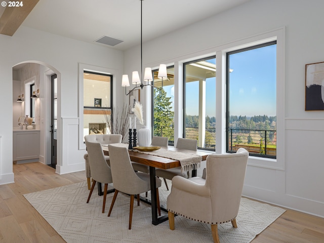 dining space with beamed ceiling and light hardwood / wood-style flooring