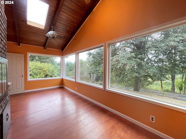 unfurnished sunroom with vaulted ceiling with skylight and wood ceiling