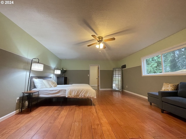 bedroom with wood-type flooring, ceiling fan, and a textured ceiling