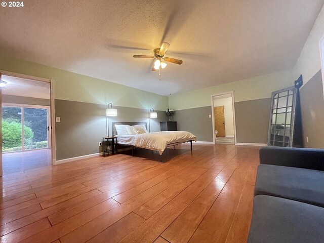 unfurnished bedroom with a textured ceiling, access to outside, ceiling fan, and hardwood / wood-style flooring