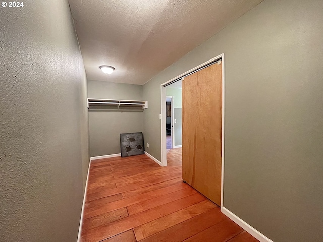 hall featuring a textured ceiling and hardwood / wood-style floors