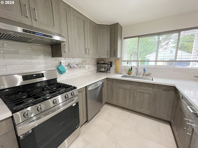 kitchen featuring appliances with stainless steel finishes, sink, and decorative backsplash