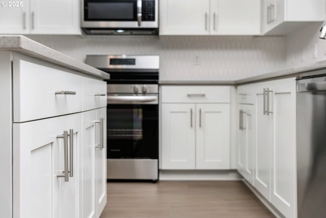 1643 NE Josephine Ct Unit 175, Estacada, OR 97023 - kitchen with stainless steel appliances, white cabinetry, and light wood-style flooring
