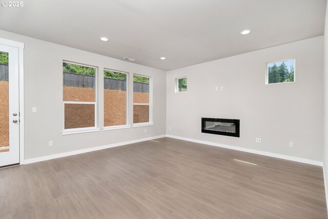 1643 NE Josephine Ct Unit 175, Estacada, OR 97023 - unfurnished living room with wood finished floors, recessed lighting, baseboards, and a glass covered fireplace