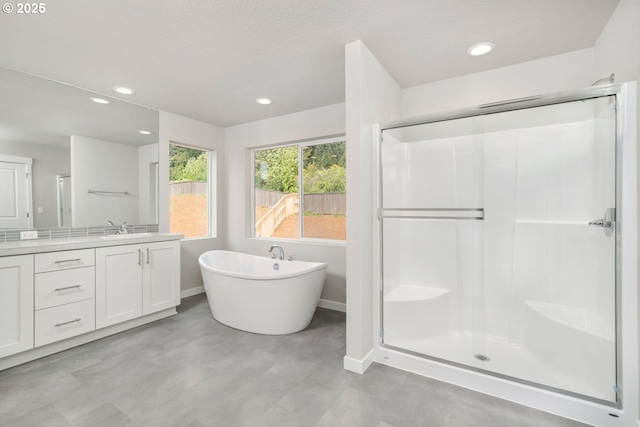1643 NE Josephine Ct Unit 175, Estacada, OR 97023 - bathroom with vanity, a stall shower, baseboards, a freestanding bath, and recessed lighting