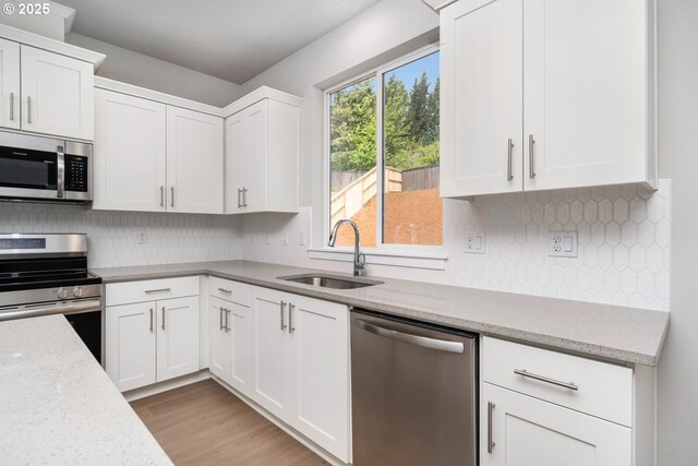 1643 NE Josephine Ct Unit 175, Estacada, OR 97023 - kitchen with appliances with stainless steel finishes, a sink, white cabinets, and backsplash