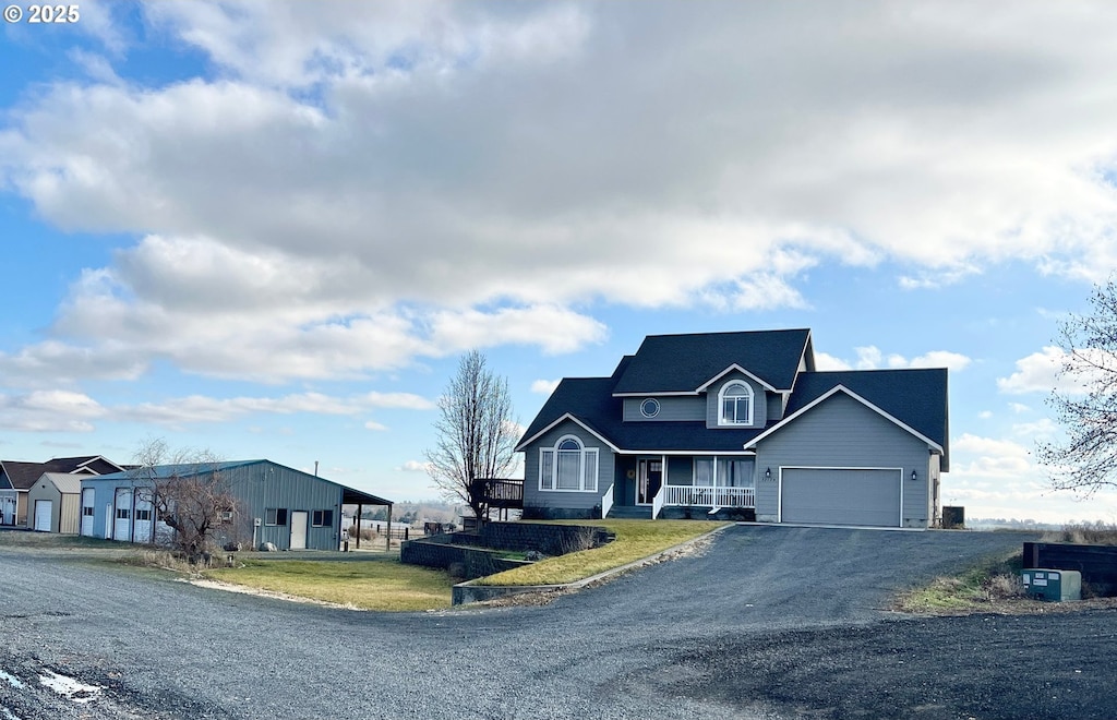 view of front of house featuring a porch, a carport, a front lawn, and a garage