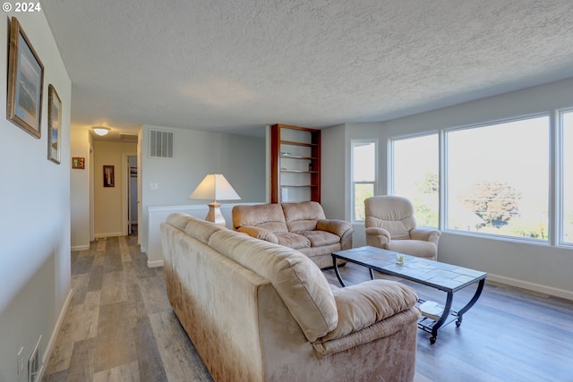 living room featuring a textured ceiling and light wood-type flooring