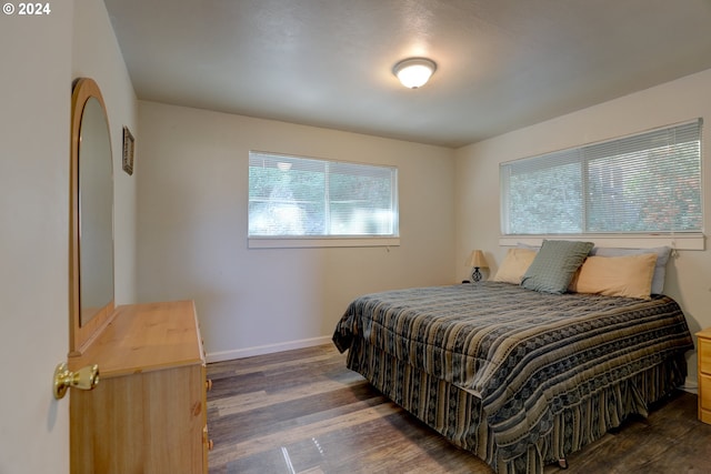 bedroom with dark hardwood / wood-style flooring