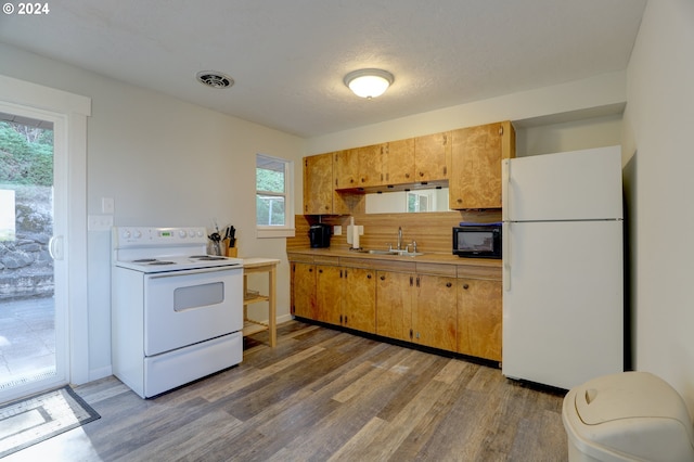 kitchen with white appliances, a textured ceiling, hardwood / wood-style floors, and sink