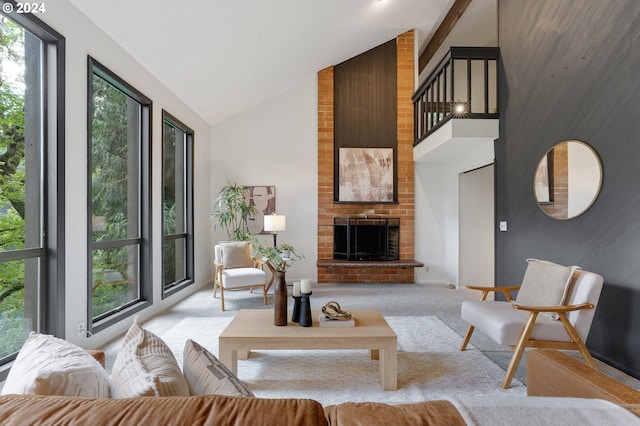 living room featuring light carpet, beamed ceiling, a fireplace, and high vaulted ceiling