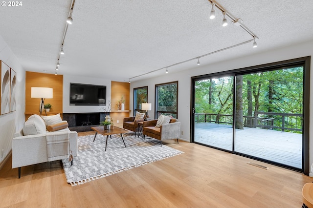 carpeted bedroom with rail lighting, connected bathroom, and high vaulted ceiling