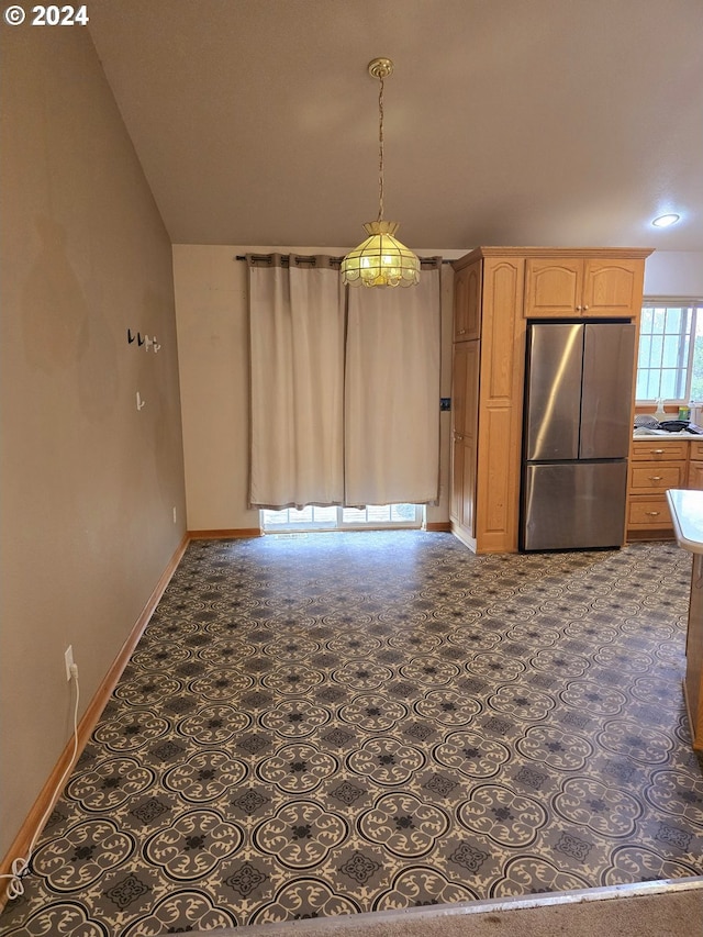 unfurnished dining area featuring dark carpet and vaulted ceiling