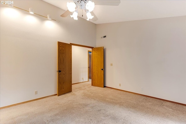 spare room featuring light carpet, high vaulted ceiling, and ceiling fan