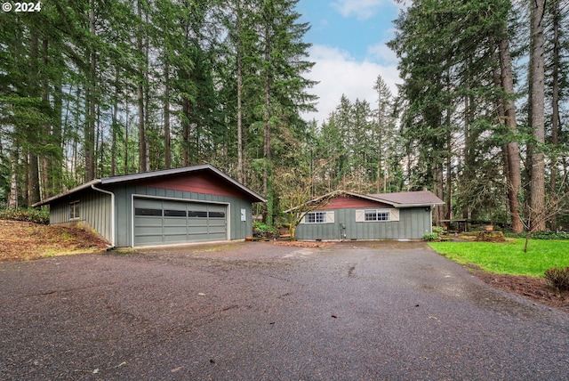 view of front of house featuring a garage, an outdoor structure, and a front lawn