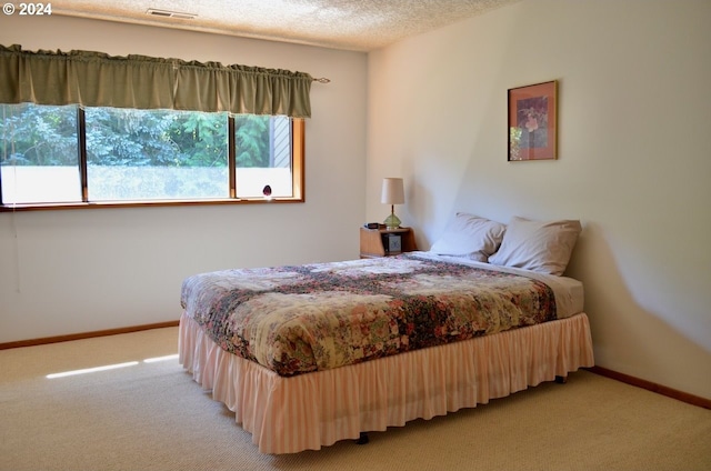 carpeted bedroom featuring a textured ceiling