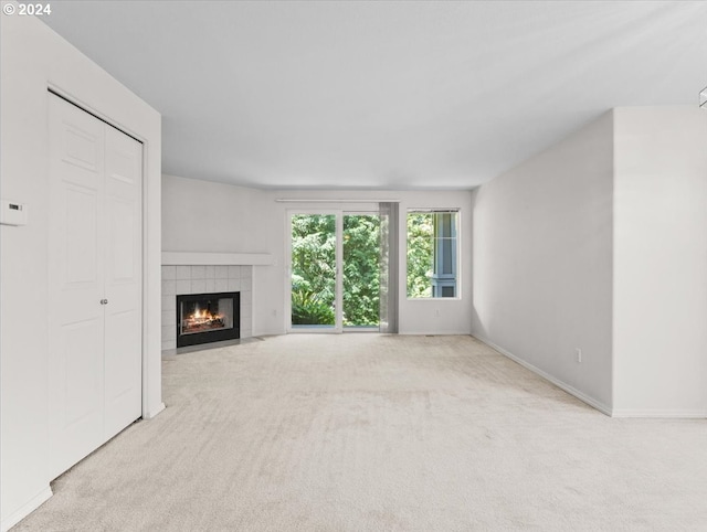 unfurnished living room featuring light colored carpet and a fireplace