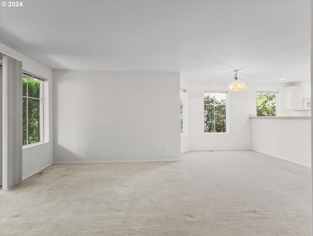 spare room with plenty of natural light and light carpet