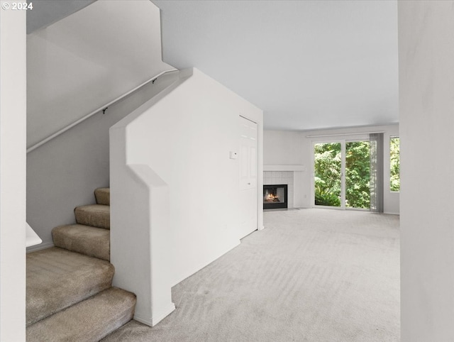 carpeted living room featuring a tile fireplace