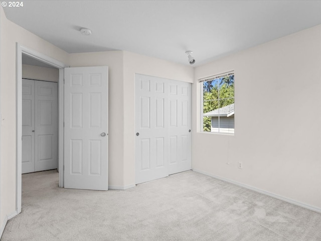 unfurnished bedroom with a closet and light carpet