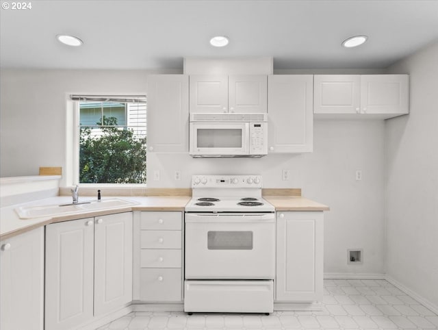 kitchen with sink, white appliances, and white cabinetry