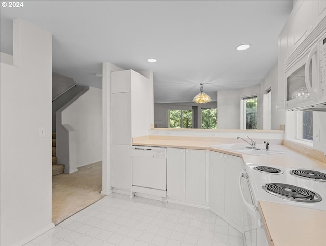 kitchen with hanging light fixtures, sink, light colored carpet, white cabinetry, and white appliances