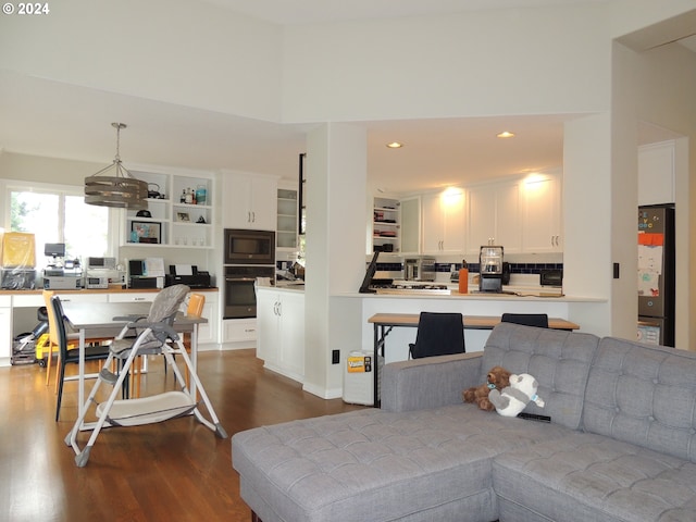 living room with a towering ceiling and dark hardwood / wood-style flooring