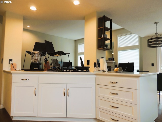 kitchen featuring a notable chandelier, white cabinetry, and hanging light fixtures