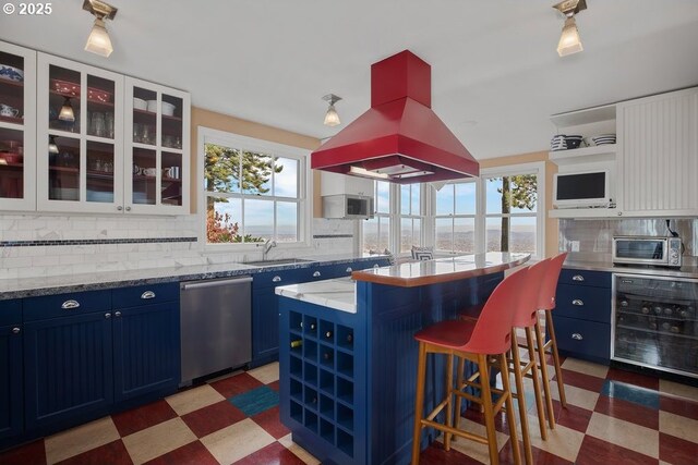 4700 SW Northwood Ave, Portland, OR 97035 - kitchen featuring blue cabinetry, beverage cooler, stainless steel appliances, a kitchen breakfast bar, and open shelves