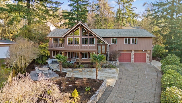 view of front of home featuring a garage, a balcony, and a patio