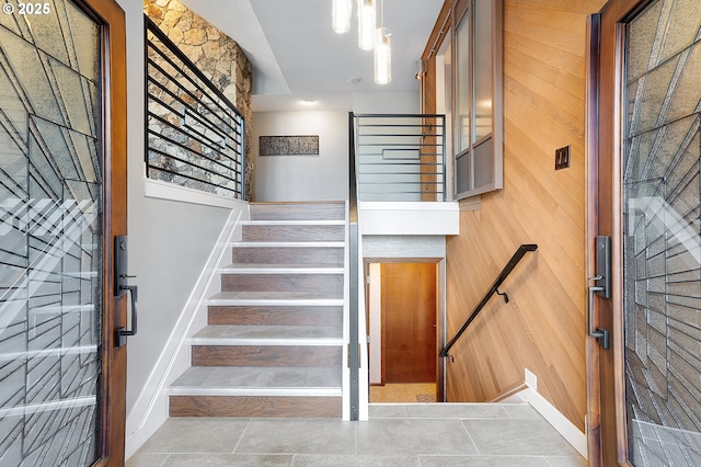 staircase featuring wooden walls