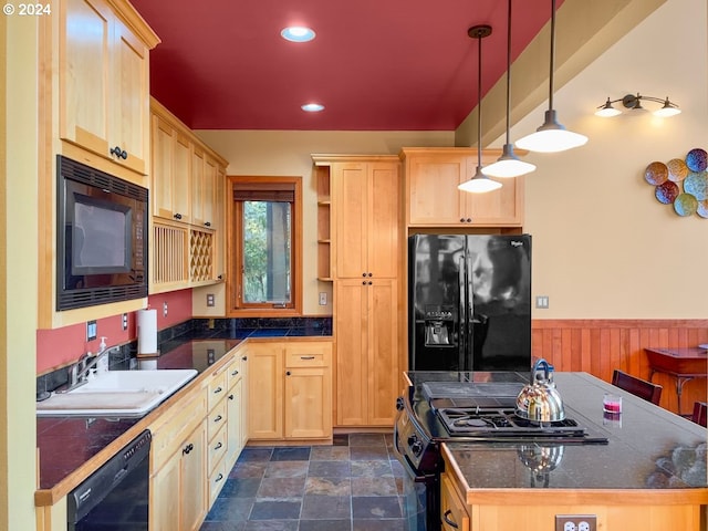 kitchen featuring black appliances, light brown cabinets, sink, and hanging light fixtures