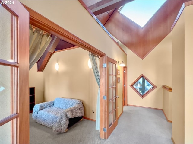 interior space with beam ceiling, light carpet, and high vaulted ceiling