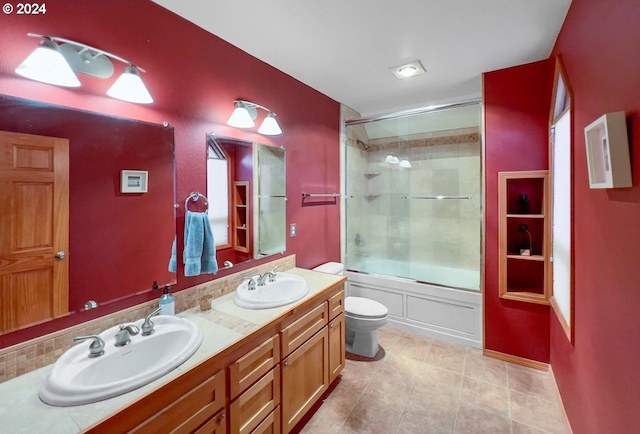 full bathroom with tile patterned floors, vanity, bath / shower combo with glass door, and toilet