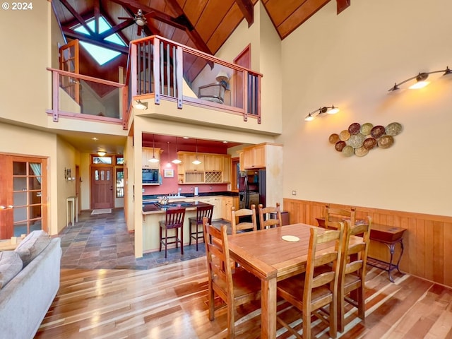 dining area featuring ceiling fan, beamed ceiling, high vaulted ceiling, and light hardwood / wood-style floors