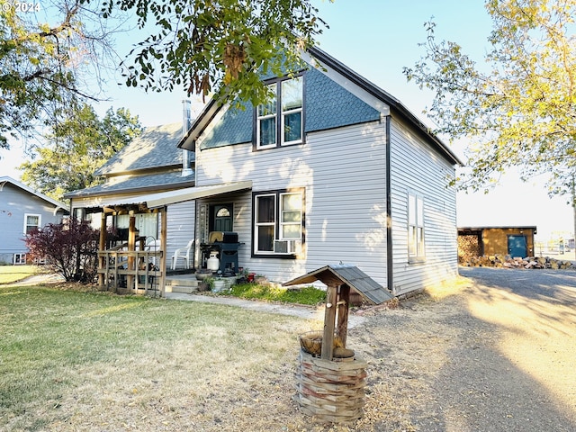 view of front of property featuring cooling unit and a front yard