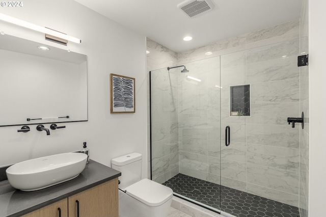 bathroom featuring toilet, a shower with shower door, and vanity