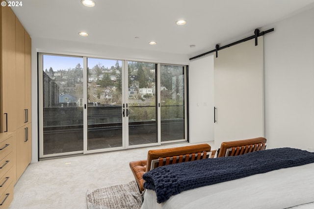 carpeted bedroom featuring a barn door