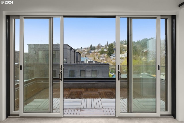 doorway to outside featuring light carpet