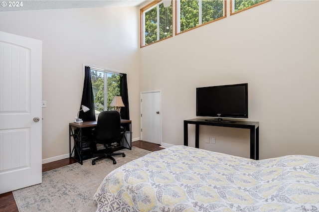 bedroom with wood-type flooring and a high ceiling