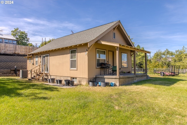 back of property featuring cooling unit and a yard