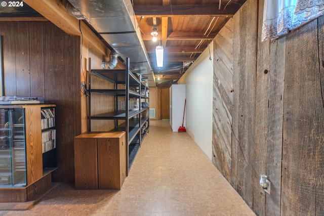 basement featuring wood walls