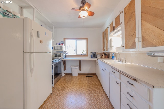 kitchen featuring ceiling fan, sink, white appliances, and white cabinetry