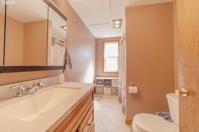 bathroom with a textured ceiling, vanity, and toilet