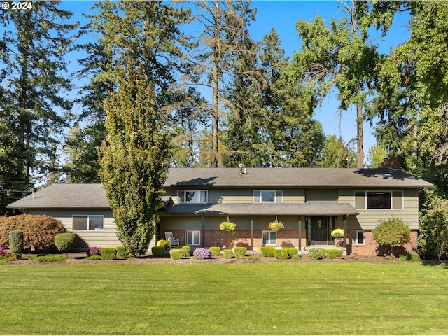 view of front of property featuring a front lawn and a sunroom