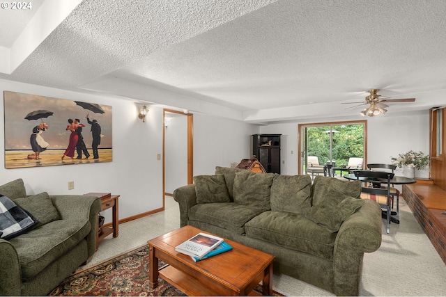 carpeted living room with ceiling fan and a textured ceiling