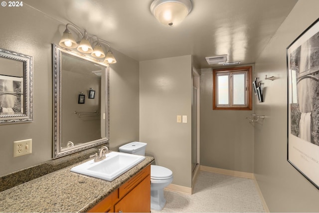 bathroom with a shower with shower door, vanity, and toilet